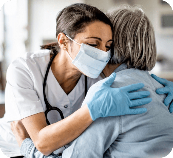 nurse hugging an elderly lady